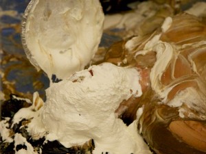 Mistress Messiér makes a pudding angel on the floor while pies are dropped on her face at the Debauchery 2013 messyplay demo.